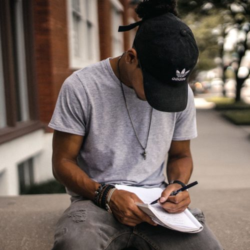 Photo of teen writing in notebook.