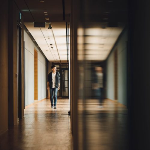 Teen walking down hallway.