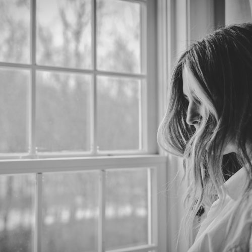 Photo of woman looking out window.