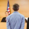 image of judge speaking to lawyer and client in a courtroom
