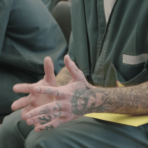 Hands of a guy talking in a group in prison
