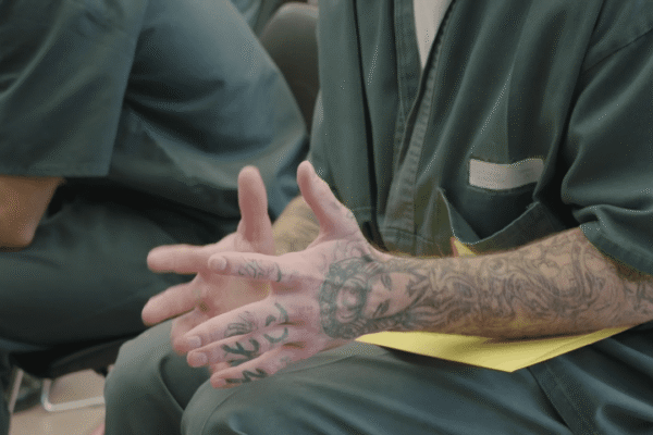 Hands of a guy talking in a group in prison
