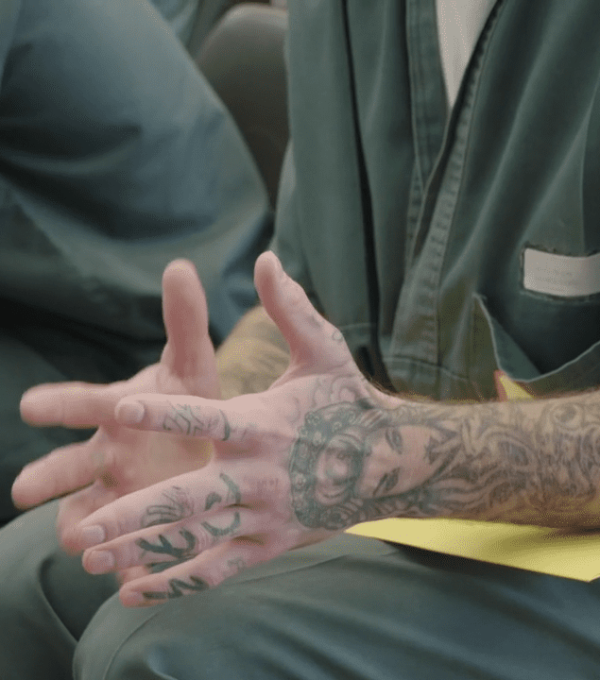 Hands of a guy talking in a group in prison