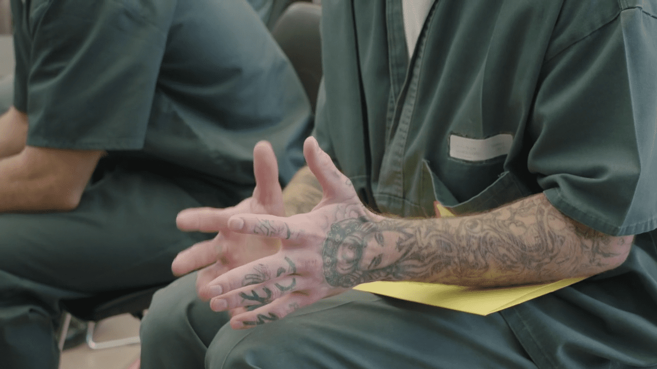 Hands of a guy talking in a group in prison