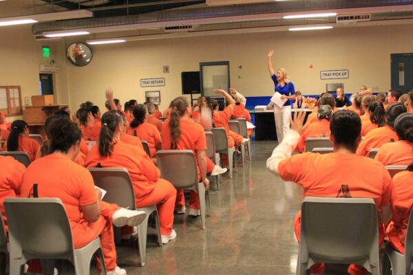 Women in prison listening to motivational speech