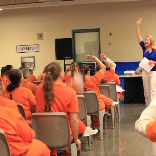 Women in prison listening to motivational speech