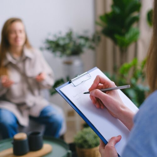 Woman taking notes on a clipboard during an appointment