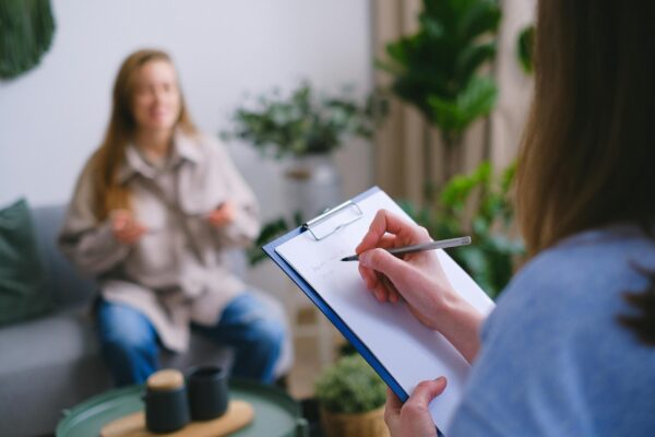Woman taking notes on a clipboard during an appointment