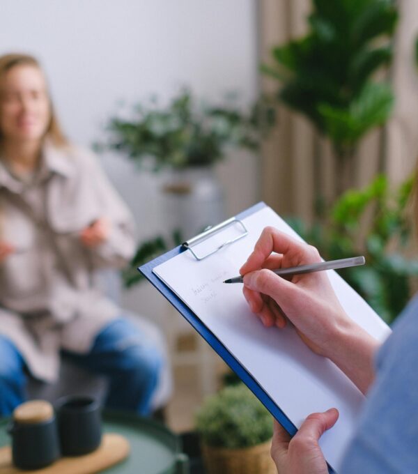 Woman taking notes on a clipboard during an appointment