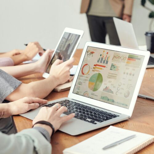 Data analysts looking at charts on laptops