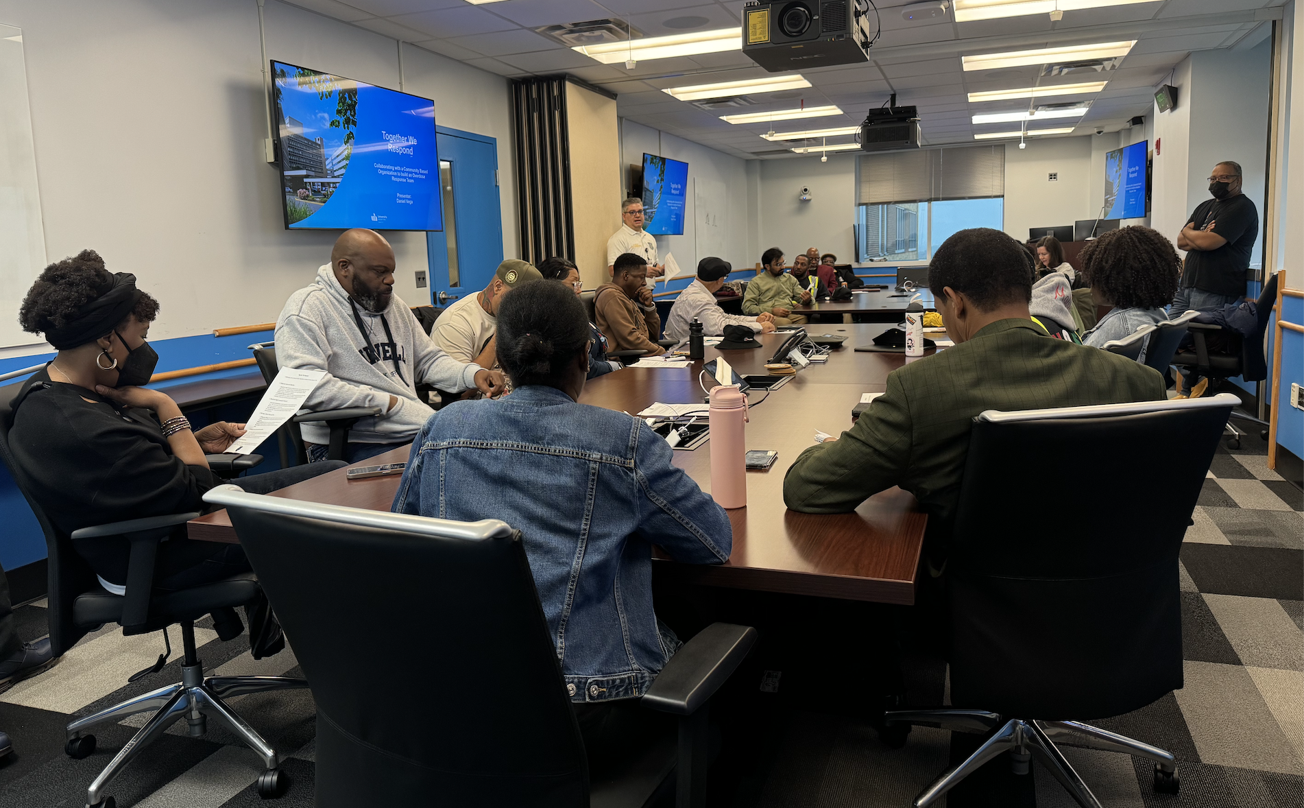 Several people are seated around tables and engaged in discussion.