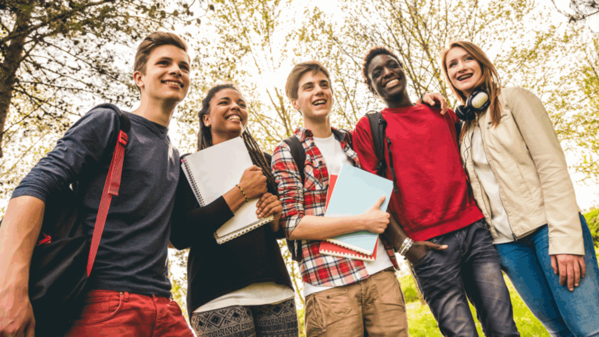 Teens standing and smiling in backpacks