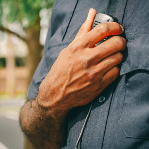 Police officer in uniform holding his radio.