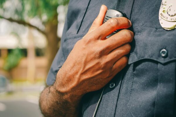Police officer in uniform holding his radio.