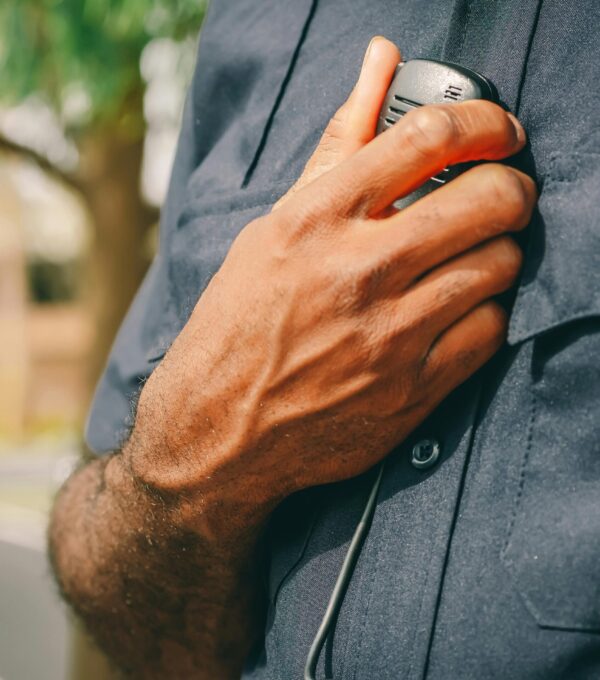 Police officer in uniform holding his radio.
