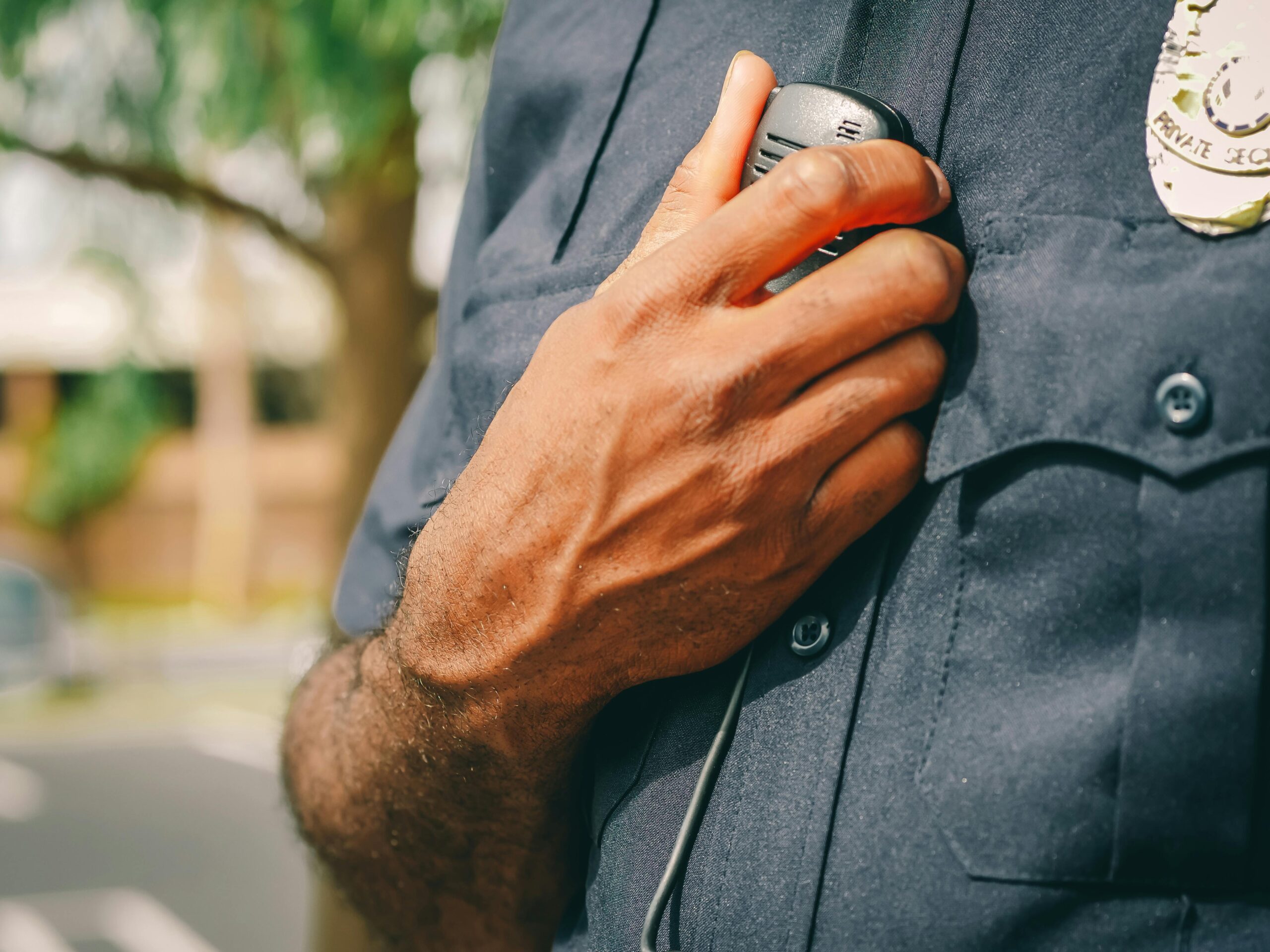 Police officer in uniform holding his radio.