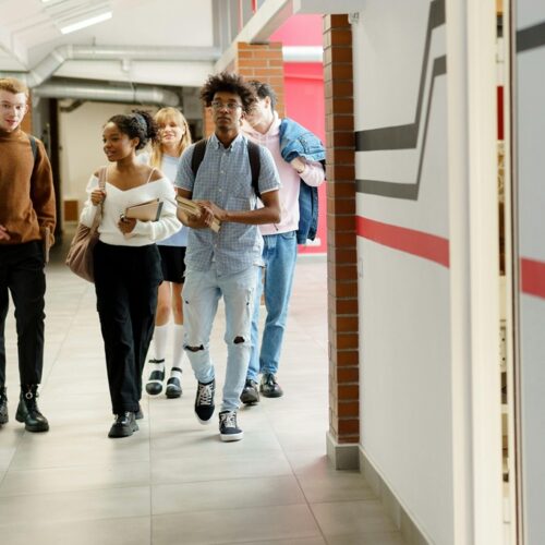 Teens walking in school hallway