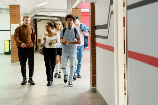Teens walking in school hallway