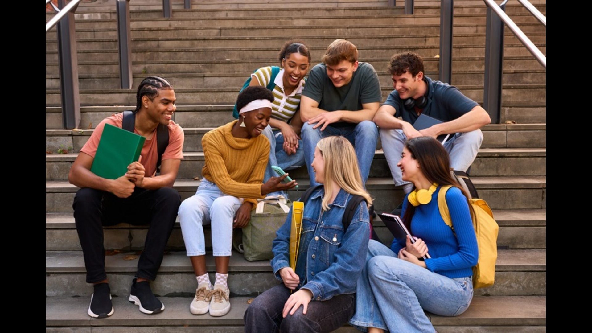 Diverse group of teen students laughing on stairs