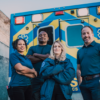 Four crisis responders standing in front of an ambulance.