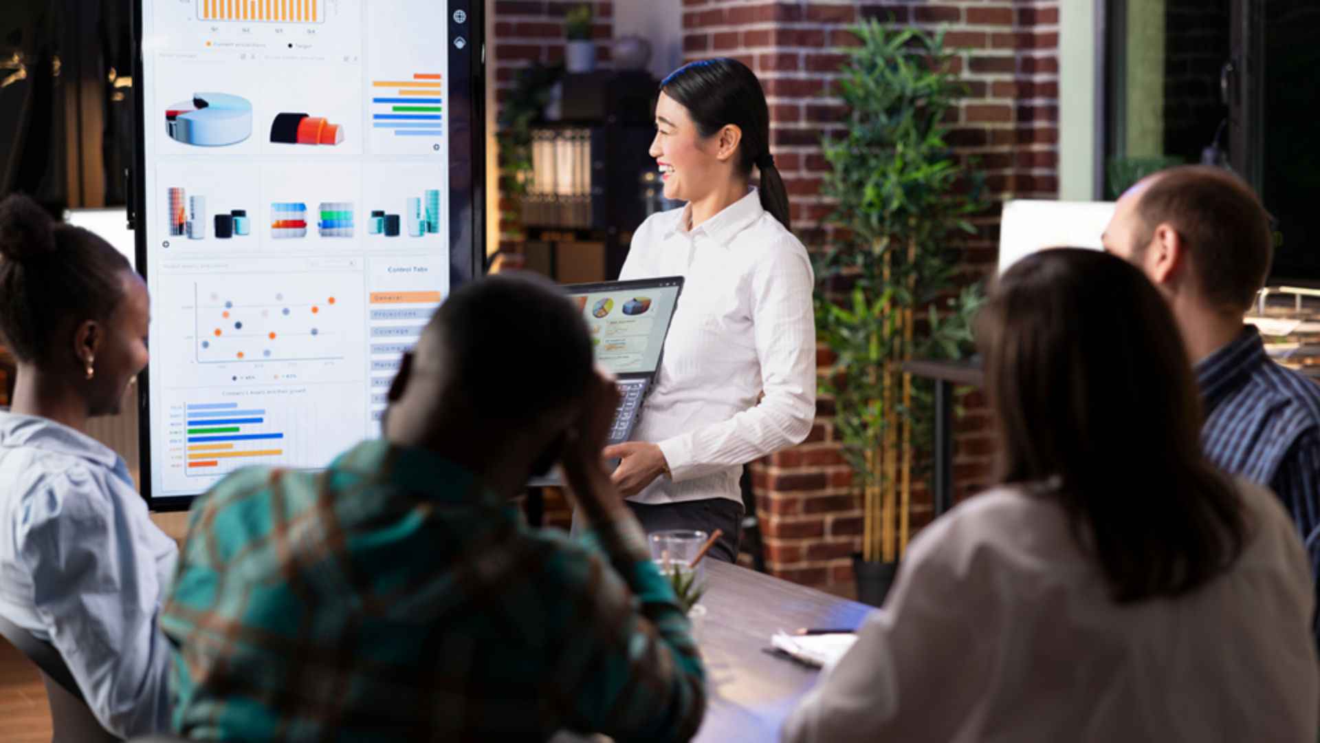 Asian woman giving data presentation with charts and graphs