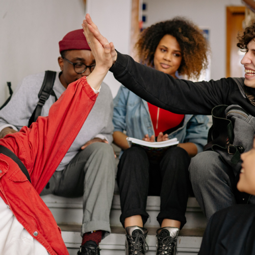 Teens high fiving in school staircase