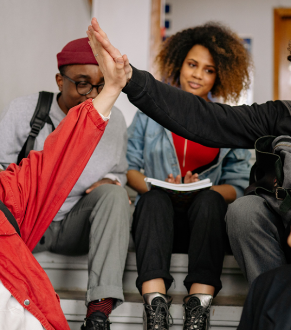 Teens high fiving in school staircase