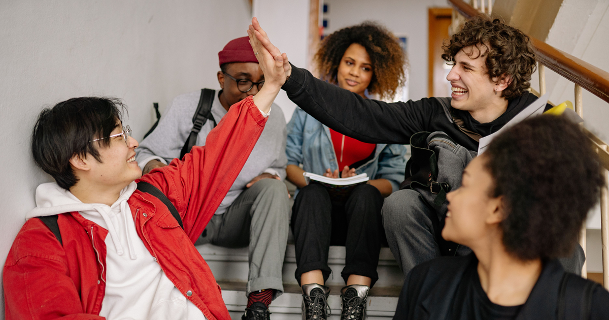 Teens high fiving in school staircase